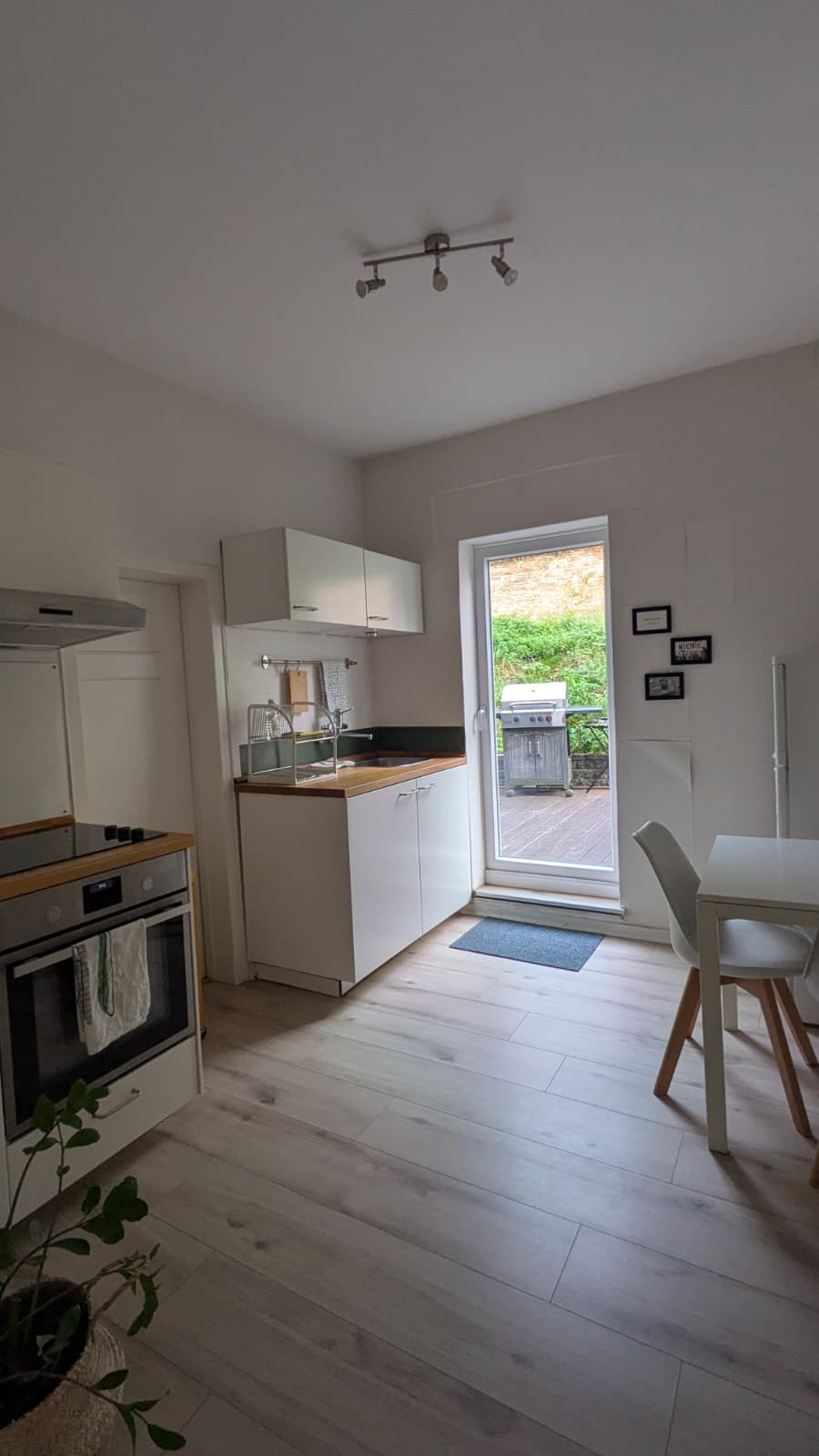 Küche mit Herd, Backofen, Spüle, Esstisch und Terrassentür